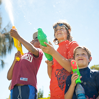 A group of boys playing with water guns.