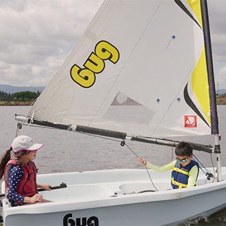 Kids in a bug sailboat.