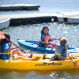 Kids playing around in their kayaks on a lake
