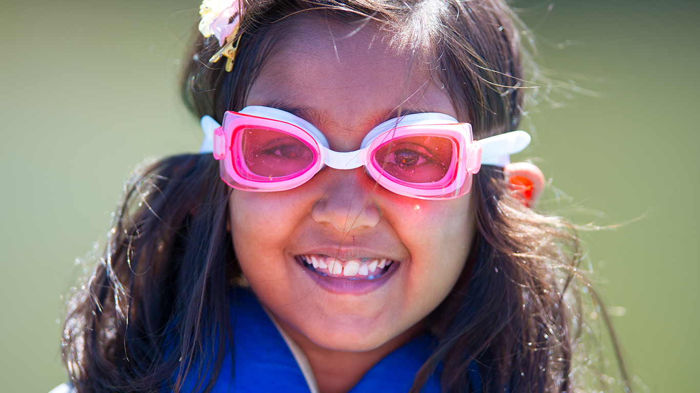A child wearing googles at shoreline lake