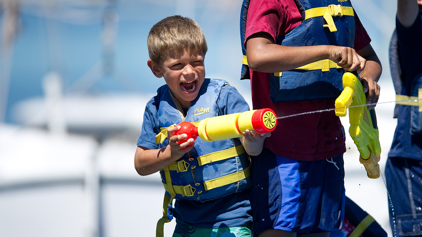 A little boy shooting a water gun.