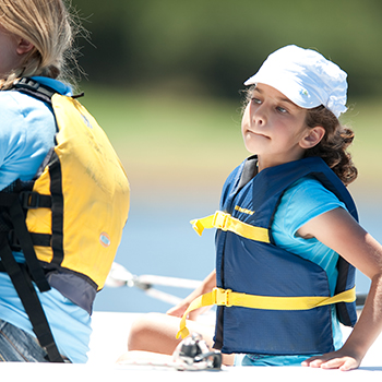 A young girl in boat wearing a life vest.