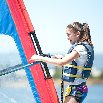 A young girl on a windsurf board