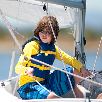 A boy on a boat pulling a line