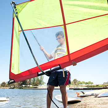 A man inspecting a windurf sail