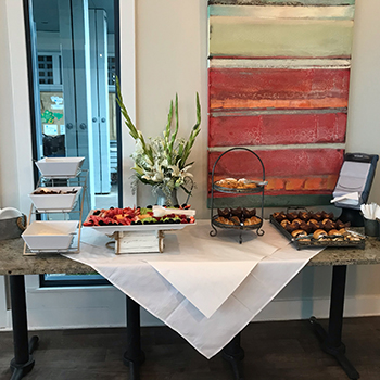 Platters of fruit and pastries set out for a meeting.