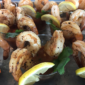 A bunch of shrimp cocktails setup for an event.