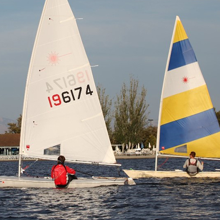 Two boats sailing fast on shoreline lake