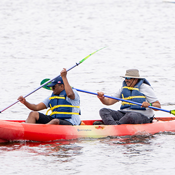 Two ocean kayaks being used on shoreline lake