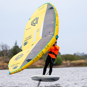 A man wingfoiling on shoreline lake