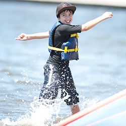 A boy sitting on the lawn listening to sailing instructions